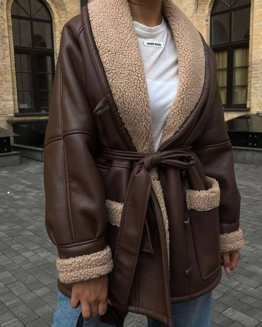 Brown leather and fur splicing coat for women, featuring long sleeves and a belted waist, perfect for stylish layering.
