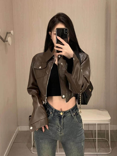 Stylish woman wearing a brown leather motorcycle jacket with flying sleeves, showcasing a trendy urban look.