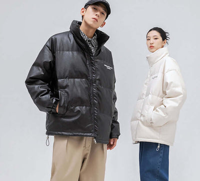 Stylish men and women wearing oversized jackets in black and white, showcasing modern winter fashion trends.