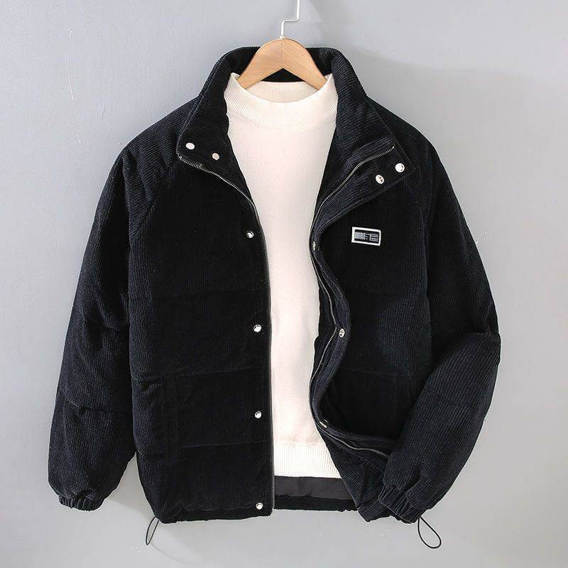 Men's black puffer jacket with zip and button closure, paired with a white sweater, hanging on a gray background.