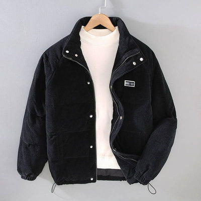 Men's black puffer jacket with zip and button closure, paired with a white sweater, hanging on a gray background.