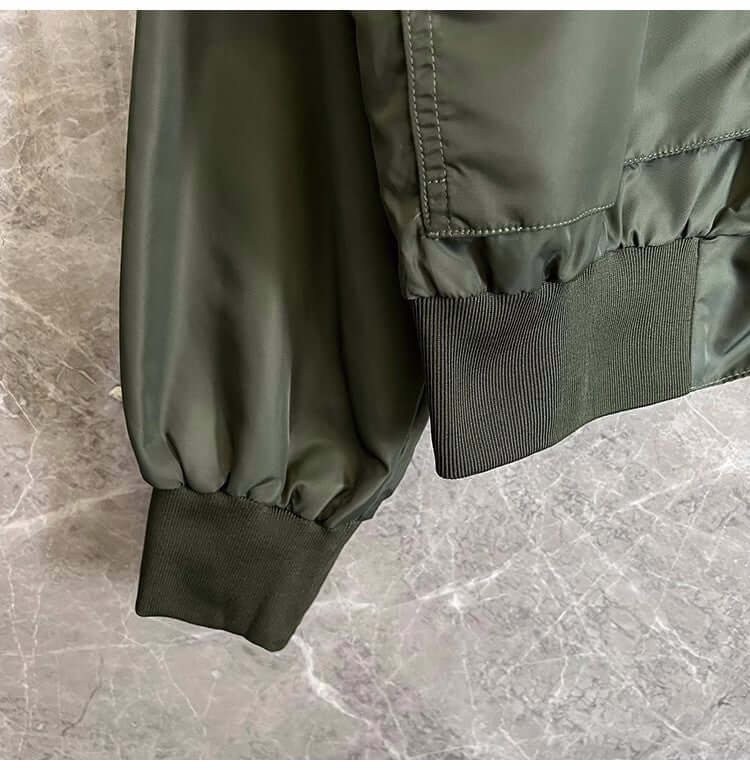 Close-up of the green sleeve cuff of a light cooked autumn jacket for men, featuring elastic ribbing.