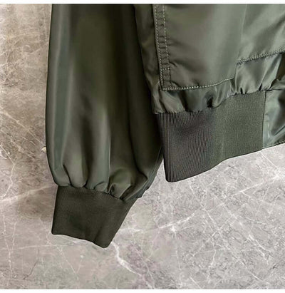 Close-up of the green sleeve cuff of a light cooked autumn jacket for men, featuring elastic ribbing.