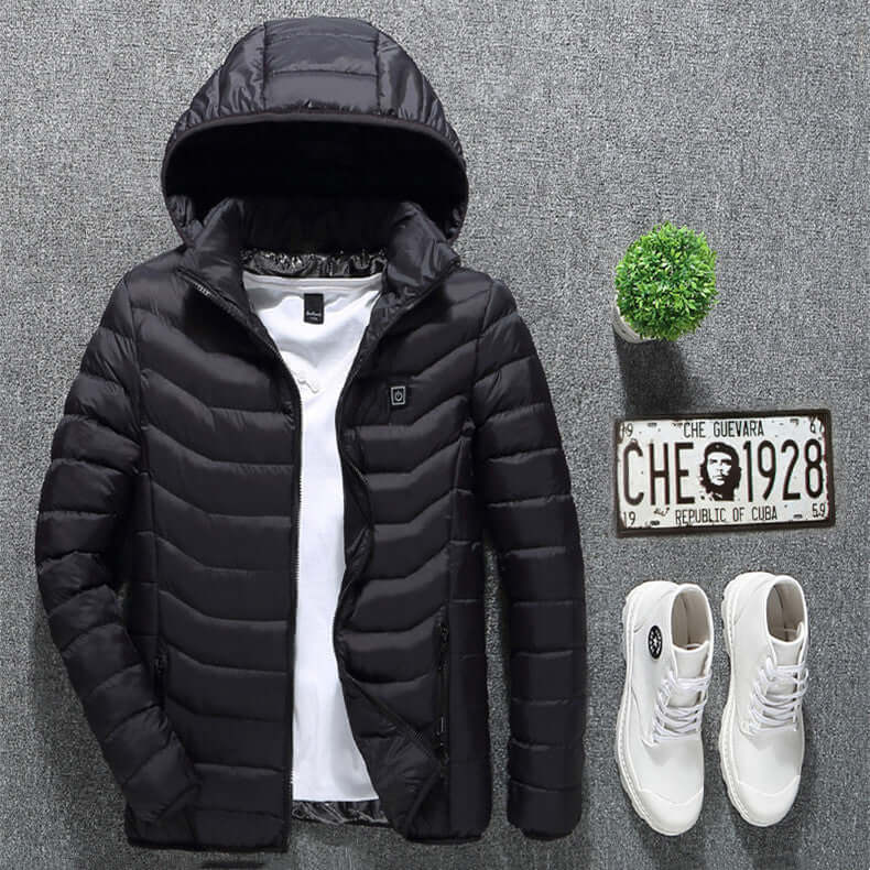 Black heated jacket with hood, layered over a white shirt, paired with white shoes and a small decorative plant.