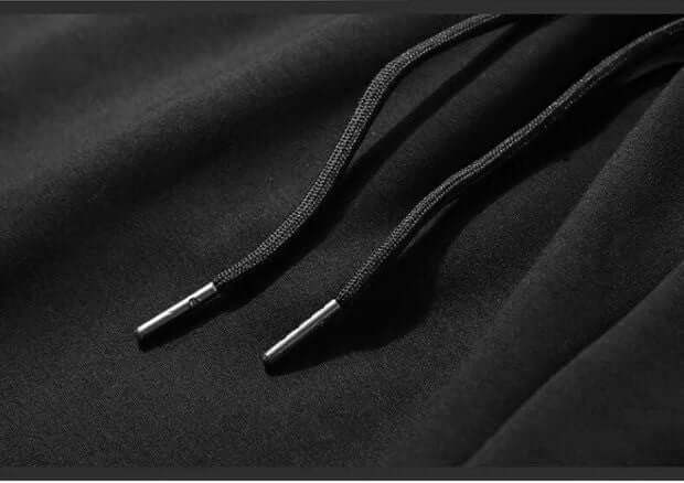 Close-up of black drawstrings on breathable thin pants for men, showcasing quality and design details.