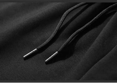 Close-up of black drawstrings on breathable thin pants for men, showcasing quality and design details.