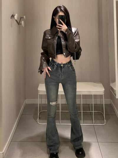 Stylish female wearing a coffee color leather motorcycle jacket with flared jeans in a modern setting.