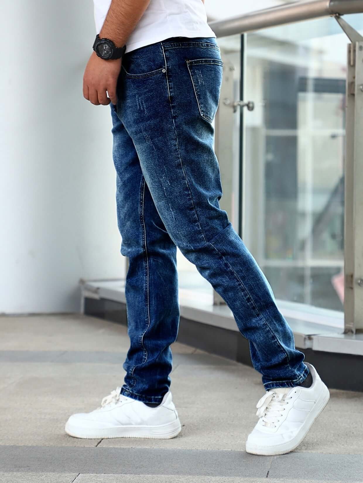 Slim fit stretch blue casual pants for men, styled with white sneakers, showcasing a modern youth fashion look.