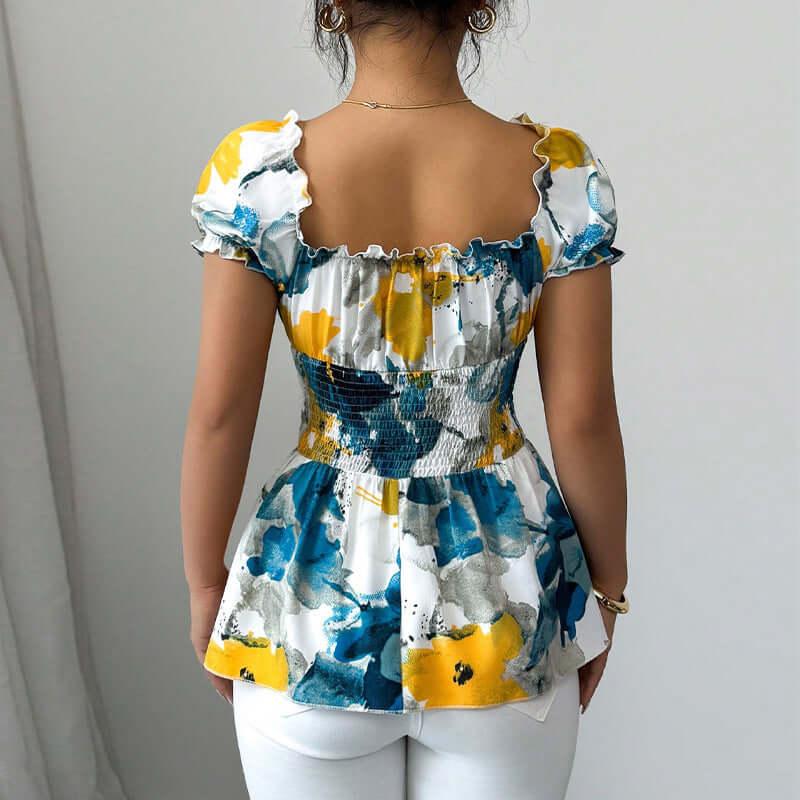 Multicolor floral pattern back view of a women's summer puff sleeve top with smocked waist.