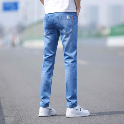 Men's slim straight stretch denim trousers in light blue, showcasing a mid waist and zipper fly, perfect for spring and summer.