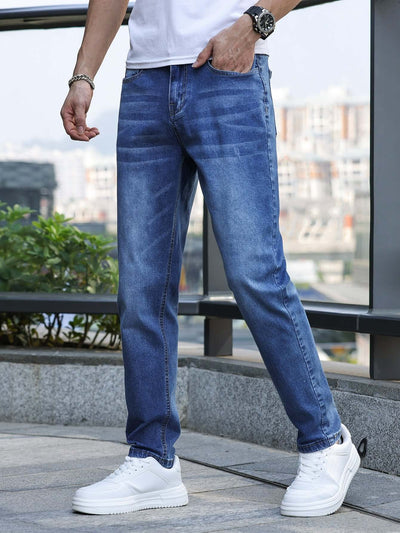Man wearing light blue stretch slim jeans with a mid waist, paired with white sneakers for a casual look.