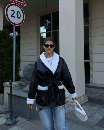 Woman wearing a Korean-style long sleeve splicing coat, combining black imitation leather and white fur, styled with sunglasses.
