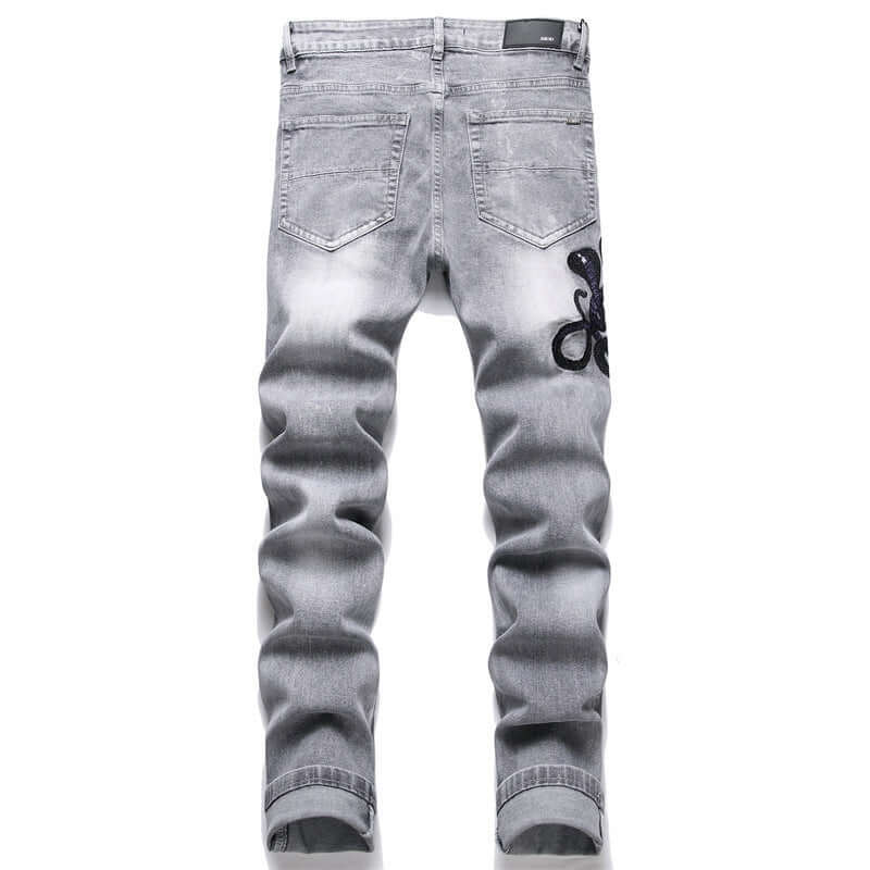 Fashion gray skinny jeans with hole patch and cobra embroidery, suitable for casual wear for men.