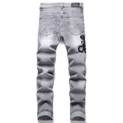 Fashion gray skinny jeans with hole patch and cobra embroidery, suitable for casual wear for men.