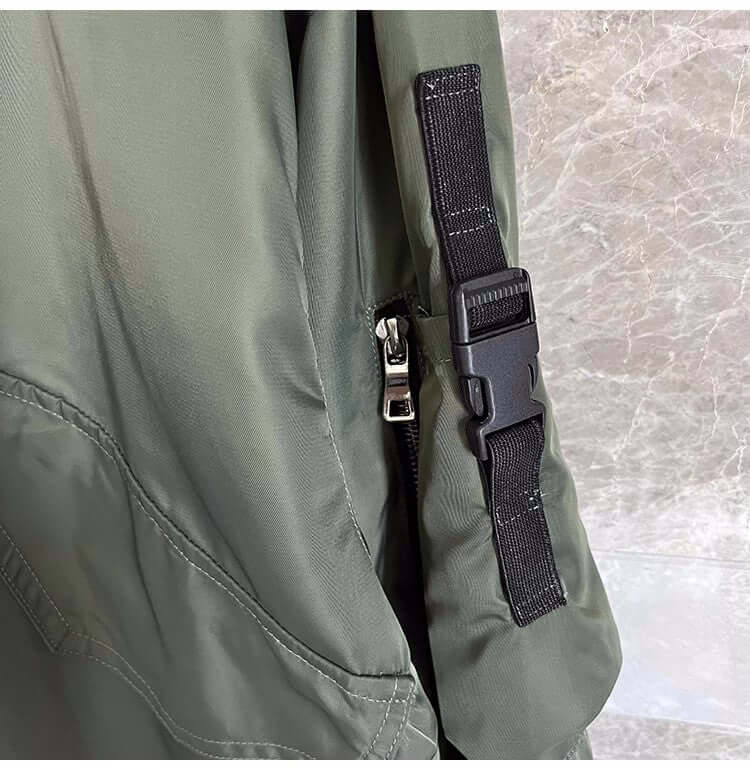 Close-up of the strap and zipper detail on a light cooked autumn jacket for men in military green.
