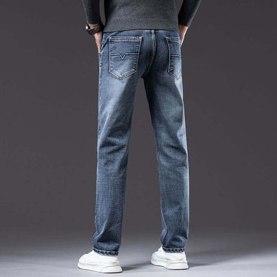 Men's blue loose straight stretch denim pants with mid waist and micro elasticity, shown from the back.