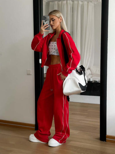 Model wearing a red sports lace trousers two-piece set, featuring a regular sleeve, with a stylish white bag.