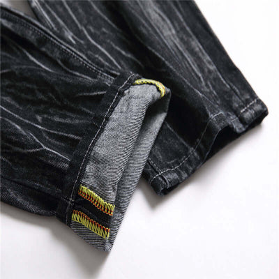 Close-up of the hem and stitching details of men's black decorative flower ripped straight jeans.