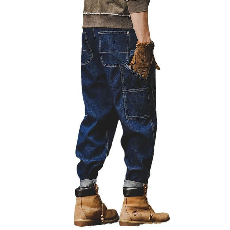 Men's retro loose workwear jeans in blue with zipper fly, styled with brown boots and a casual sweater.
