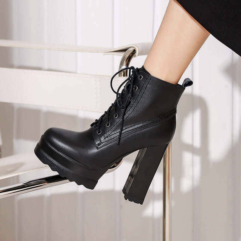 Women's chunky heel black waterproof platform boots with round toe and lace-up design.