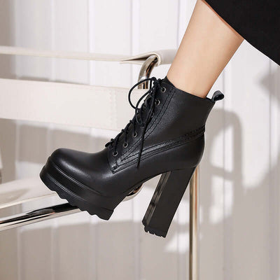 Women's chunky heel black waterproof platform boots with round toe and lace-up design.