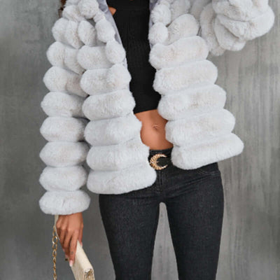 White imitation fur coat with faux fur collar, long sleeves, and stylish puffy design for women.