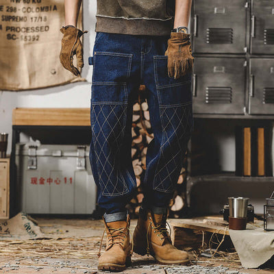 Men's retro workwear jeans in blue with stylish stitching, featuring a relaxed fit and worn with boots and gloves.