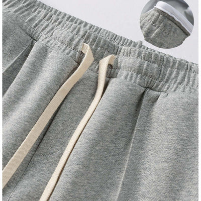 Close-up view of gray wide-leg pants featuring elastic waistband and drawstring detail.