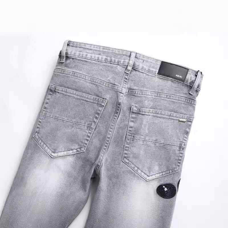 Back view of fashion gray skinny jeans with hole patch embroidery and zip placket, ideal for young adult males.