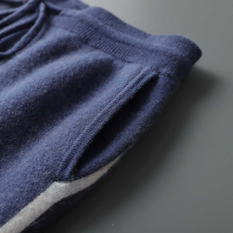 Close-up of navy blue knitted trousers showcasing pocket and soft cashmere fabric for men's casual wear.