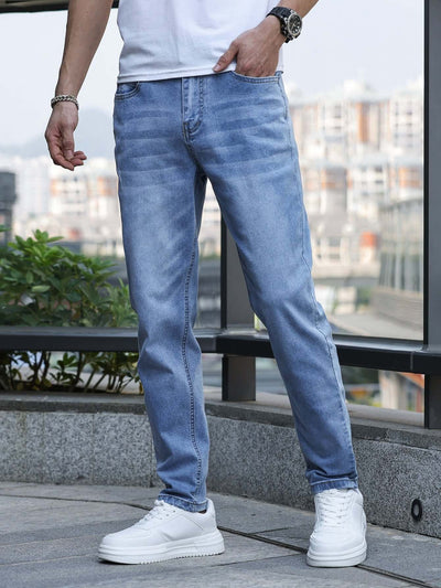 Man wearing light blue stretch slim jeans with white sneakers, styled for casual and comfortable daily wear.