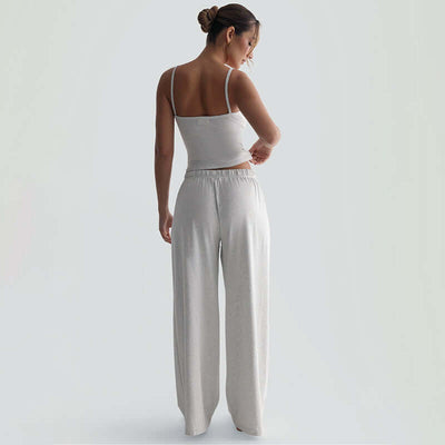 Back view of a woman wearing sleeveless backless suspender trousers suit in gray, showcasing a casual yet chic style.