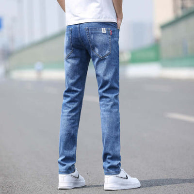 Men's slim straight stretch denim trousers in light blue, perfect for spring and summer, showcased on a model outdoors.