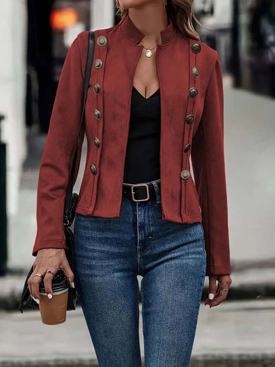 Stylish female model wearing a retro long-sleeved deerskin velvet coat in rust color, paired with jeans and holding a coffee.