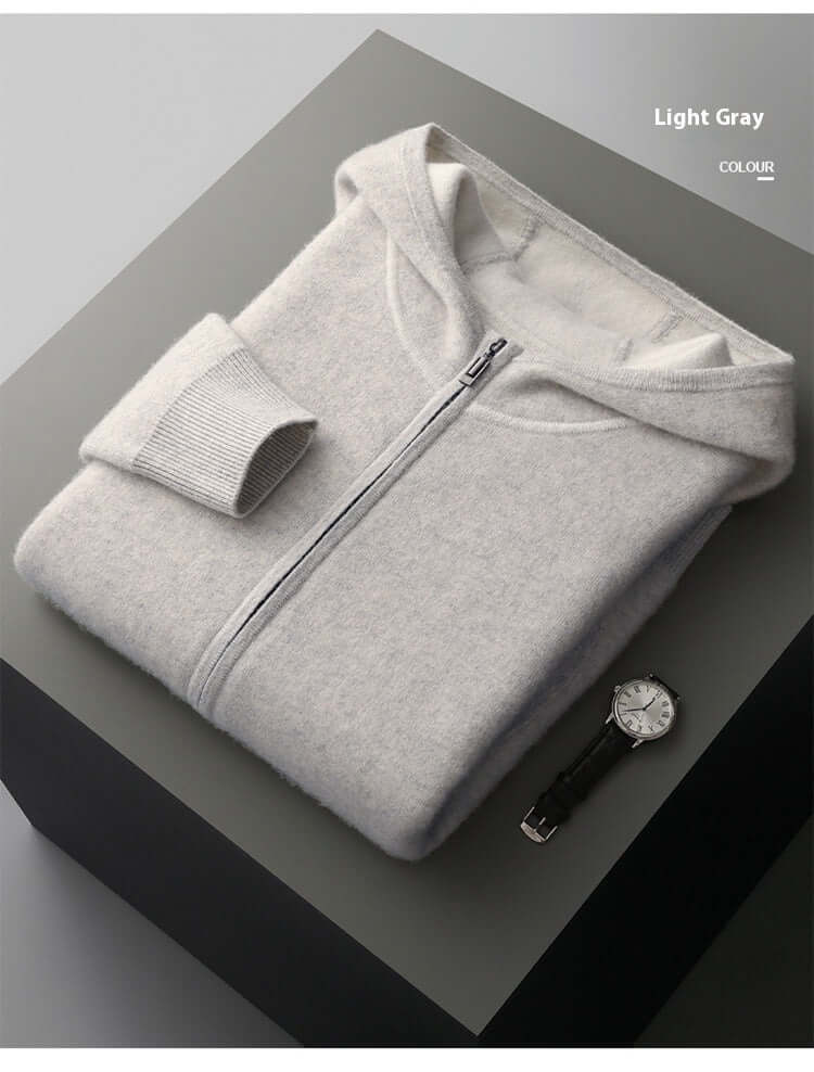 Men's thick knitted light gray hooded jacket displayed on a table with a watch, showcasing casual style and comfort.